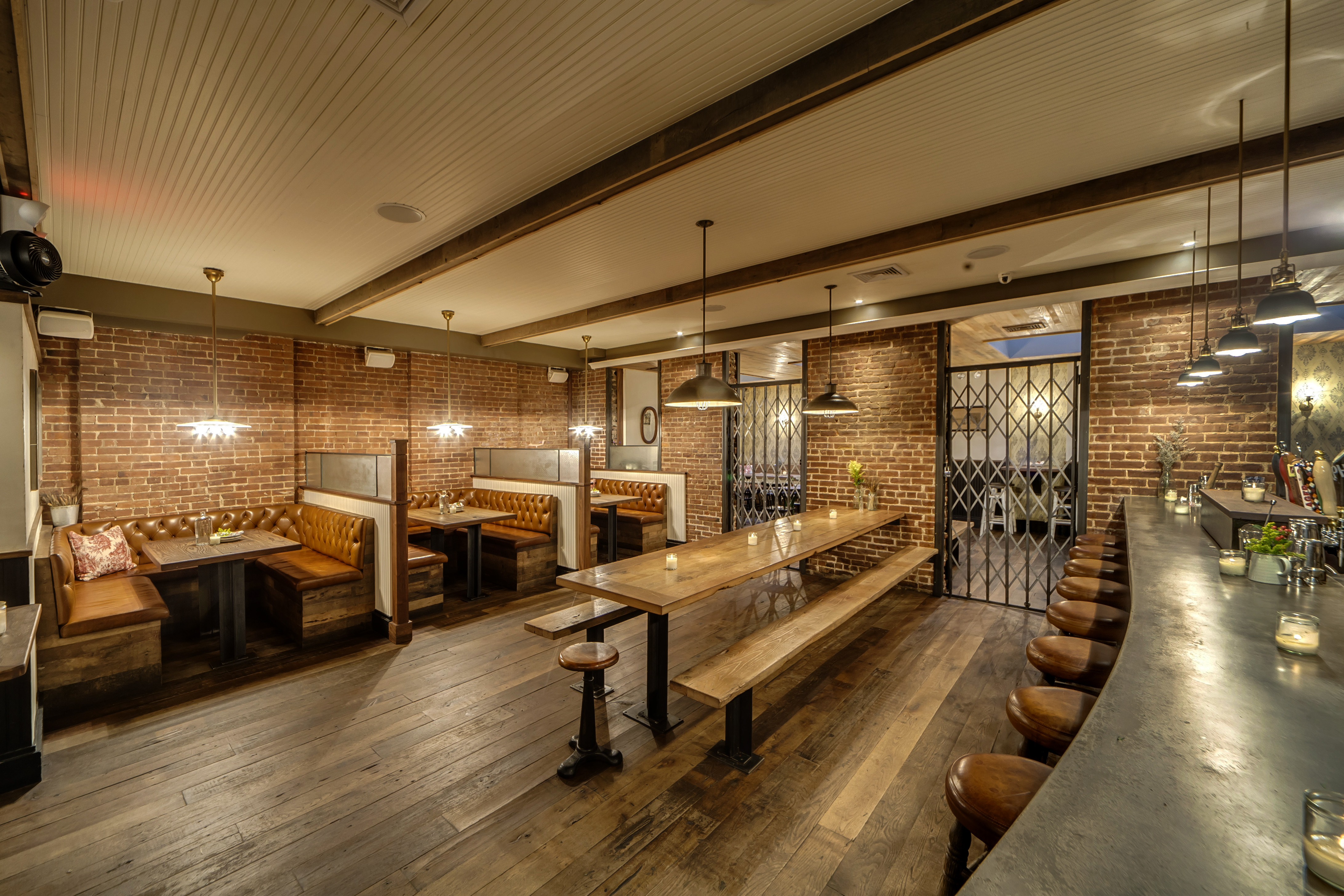 The pillow-lined benches, framed old portraits, and candlelit interior creates an intimate and inviting rustic atmosphere.